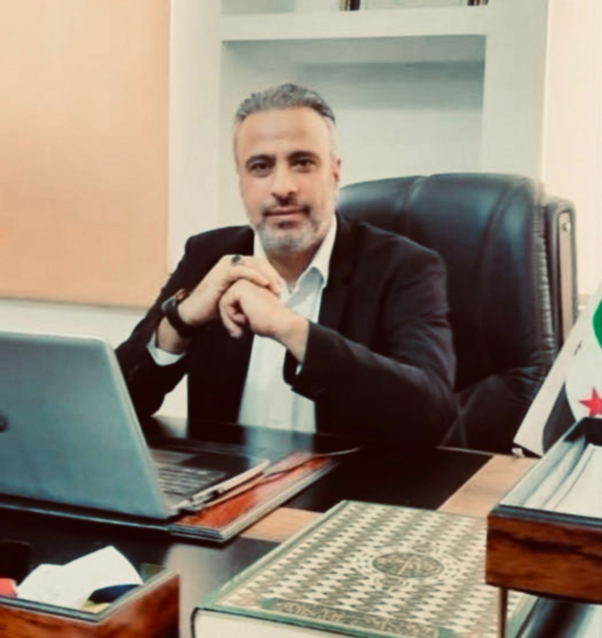 د. فواز العواد — المشرف العام لمركز طمأنينة، جالس على طاولة العمل